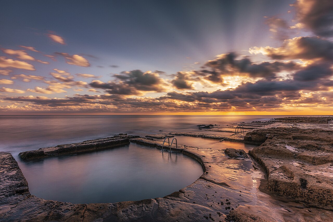 Victorian-era rock-cut swimming bath at Fond Għadir at sunrise