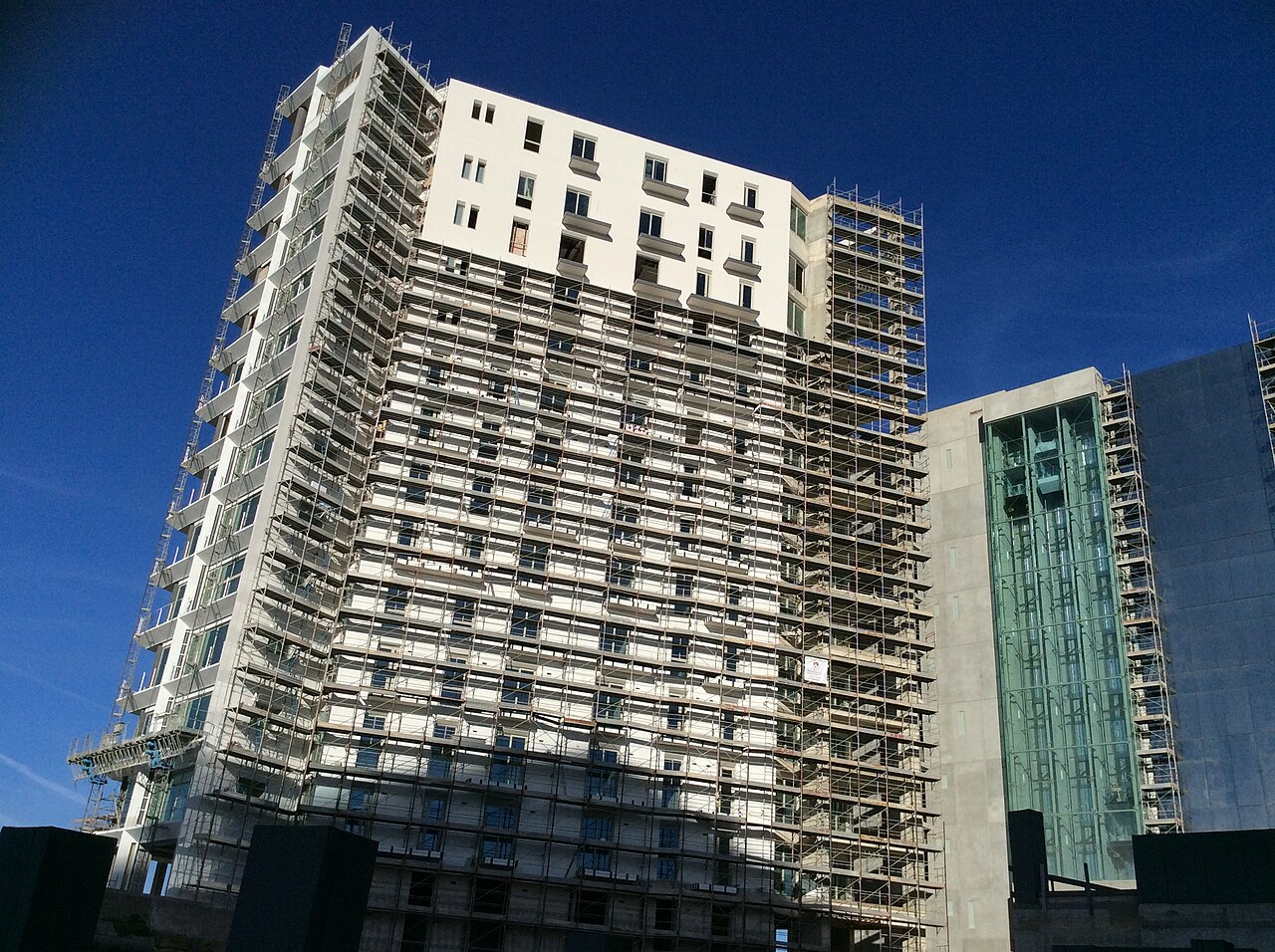 High-rise building under construction wrapped in scaffolding at Tigné