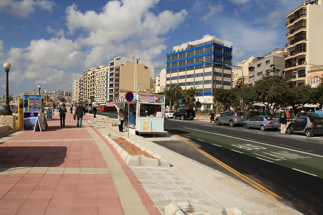 Wide seafront pavement and road along The Strand in Sliema, with a…
