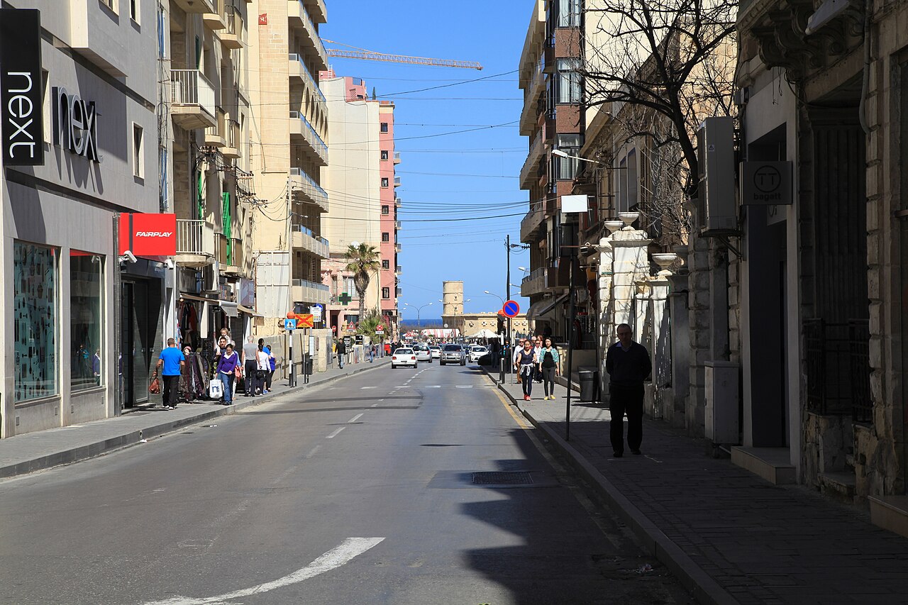 Tower Road in Sliema lined with shops and apartment blocks, with…